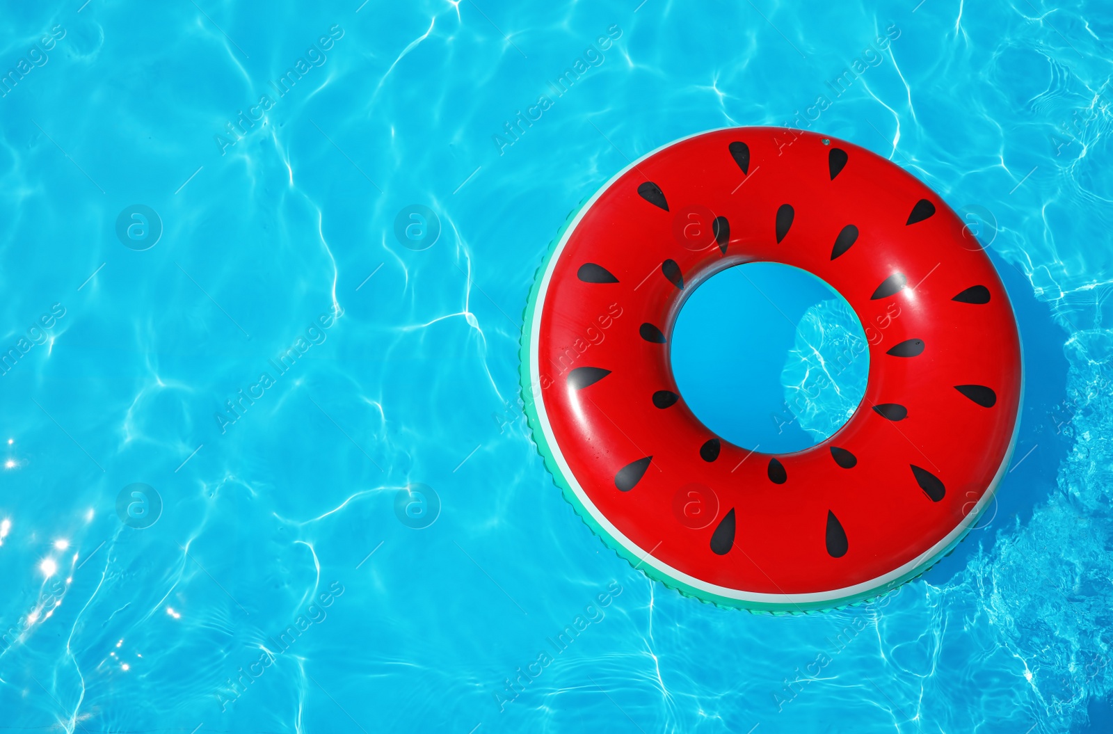 Photo of Inflatable ring floating in swimming pool on sunny day, top view with space for text