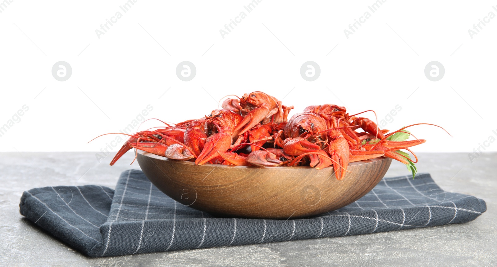 Photo of Delicious boiled crayfishes on grey table against white background