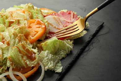 Photo of Delicious salad with Chinese cabbage, tomatoes and onion served on black table, closeup