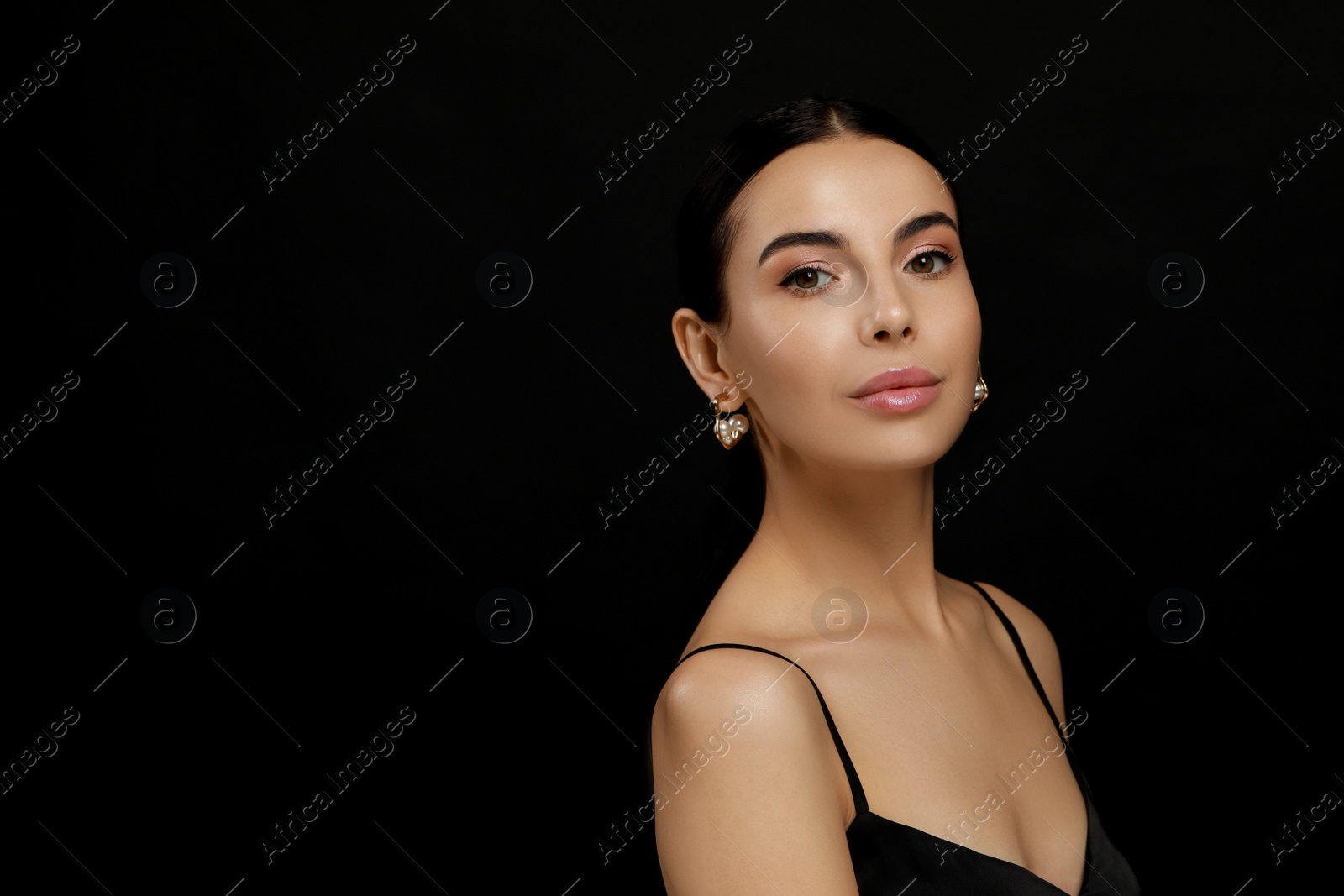 Photo of Young woman with elegant pearl earrings on black background, space for text