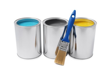Cans with different paints and brush on white background