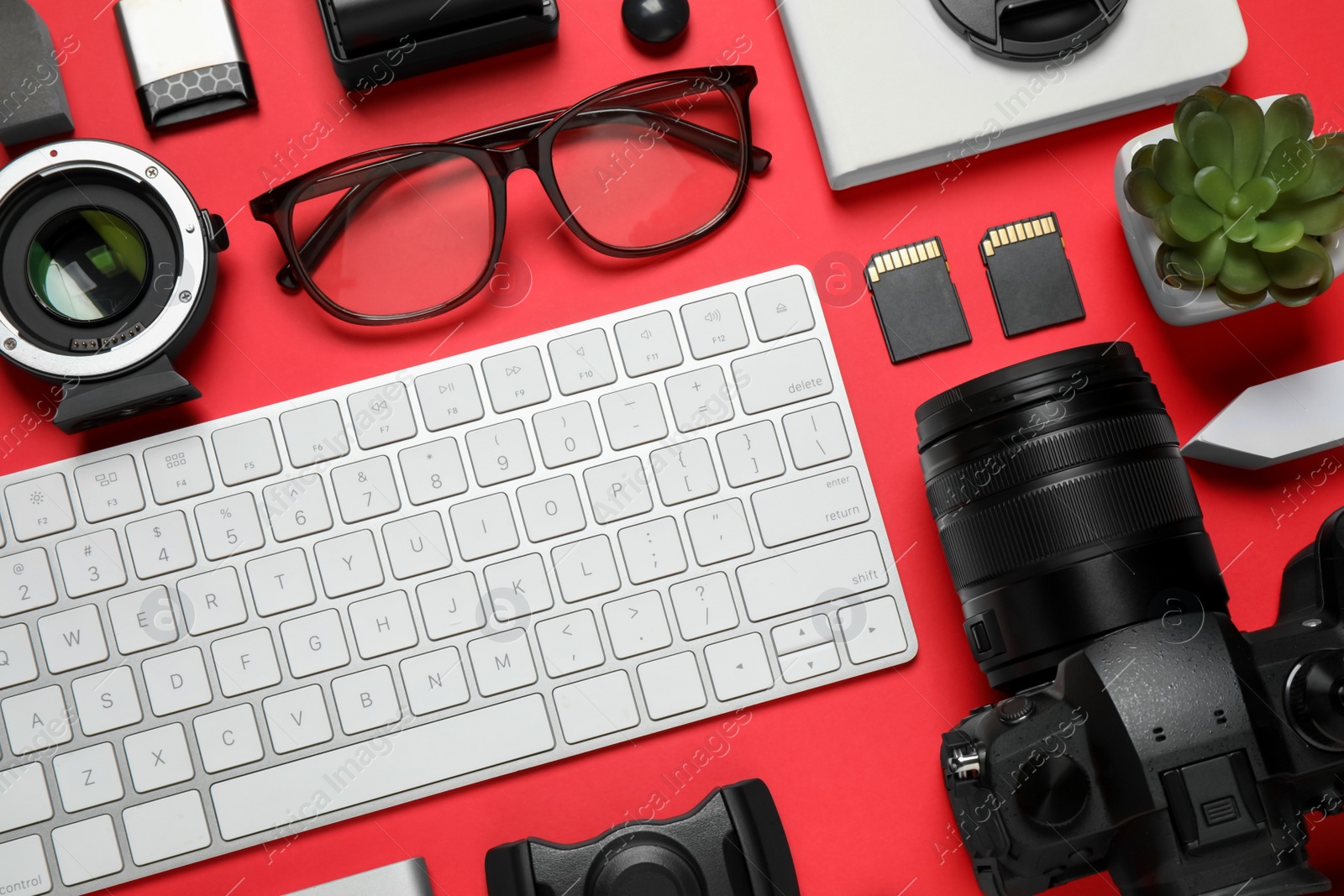 Photo of Flat lay composition with camera and video production equipment on red background