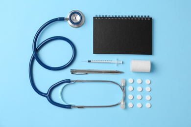 Photo of Flat lay composition with medical equipment and pills on color background