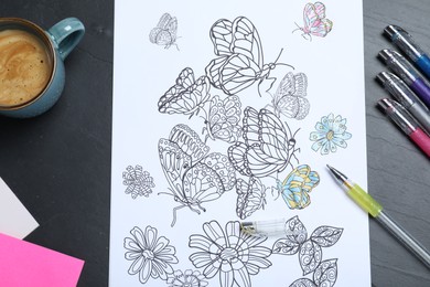 Photo of Antistress coloring page, pens and coffee on black table, flat lay