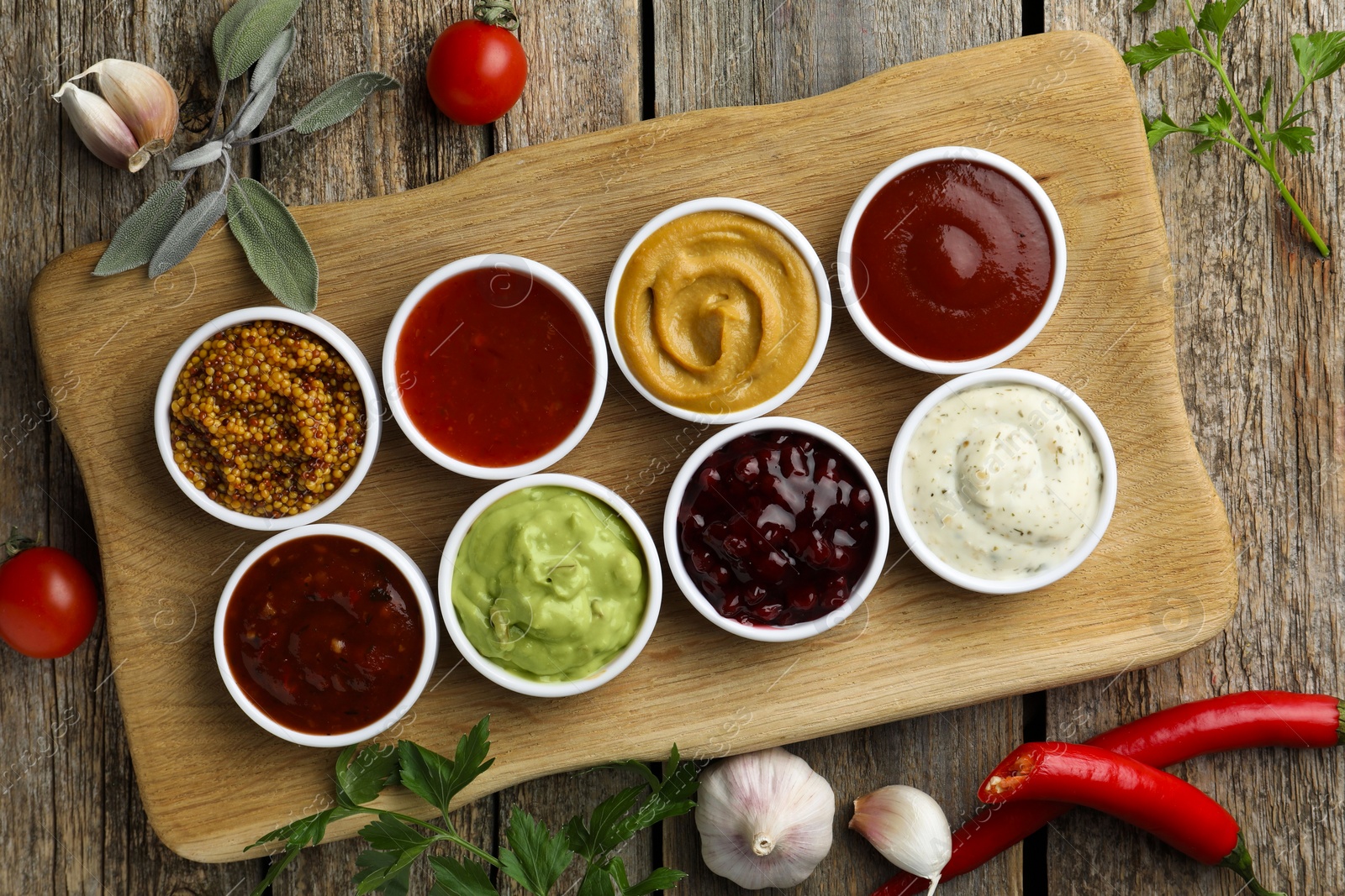 Photo of Different tasty sauces in bowls and ingredients on wooden table, top view