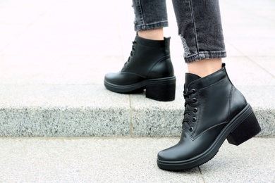 Photo of Woman wearing comfortable stylish boots outdoors, closeup