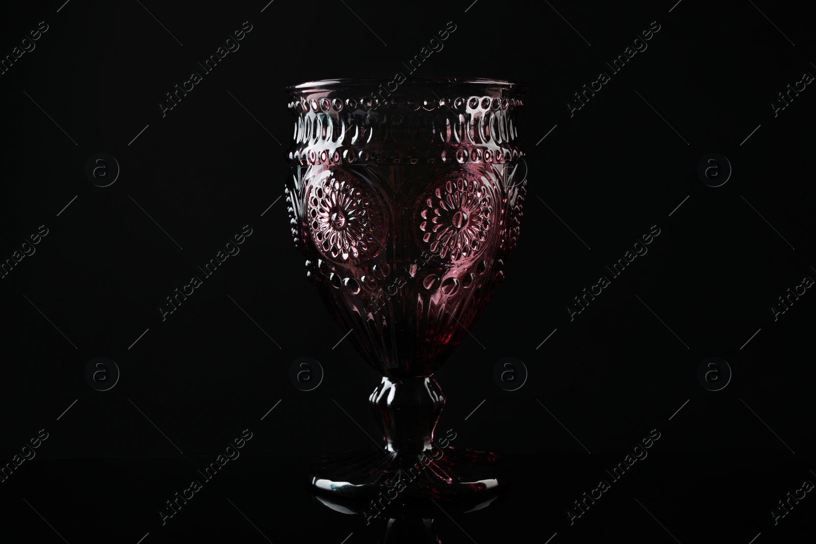 Photo of Elegant empty colorful glass on black background