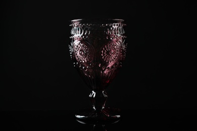 Photo of Elegant empty colorful glass on black background