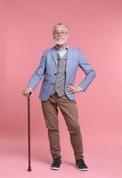Photo of Senior man with walking cane on pink background