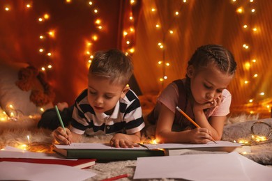 Photo of Children drawing in play tent at home