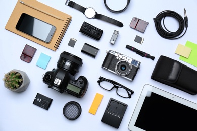 Flat lay composition with equipment for professional photographer on white background