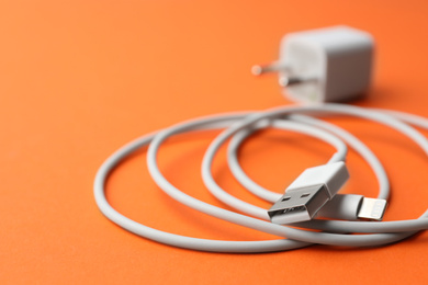 Photo of USB charge cable on orange background, closeup. Space for text