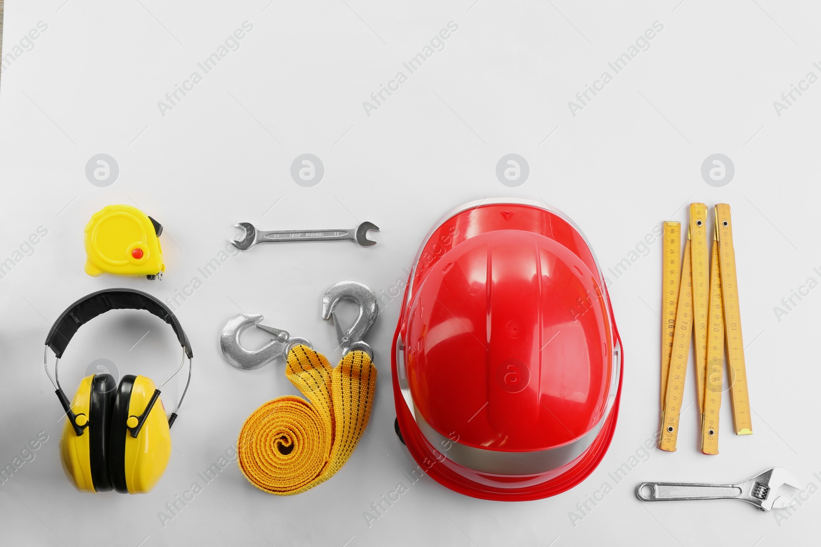 Photo of Flat lay composition with construction tools and safety equipment on white background. Space for text