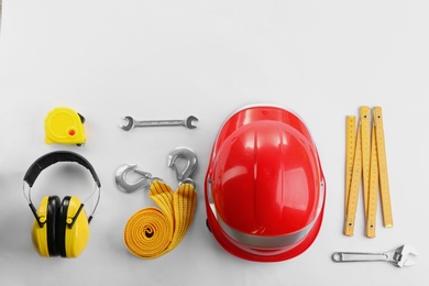 Photo of Flat lay composition with construction tools and safety equipment on white background. Space for text