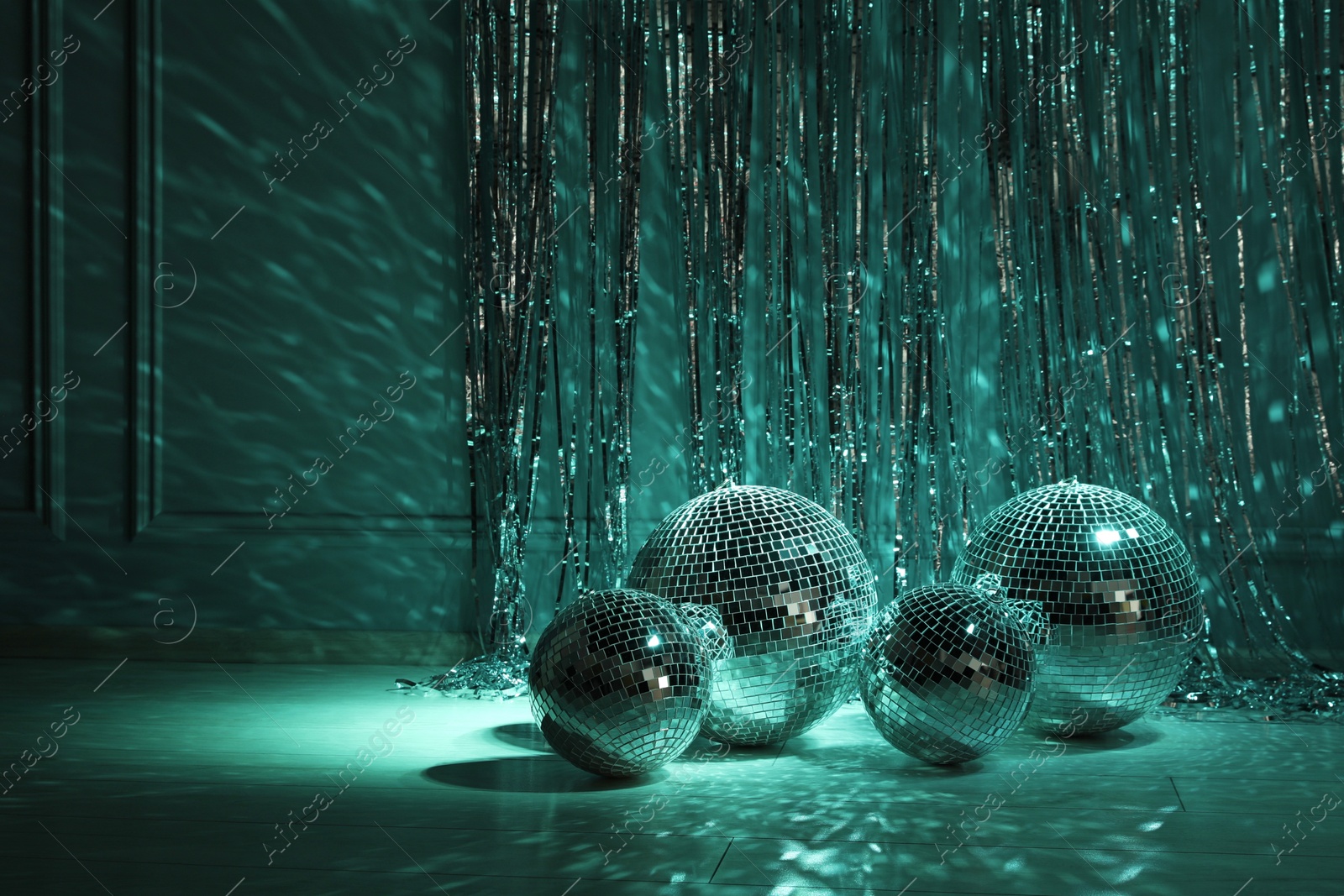 Photo of Shiny disco balls indoors, toned in dark green. Space for text