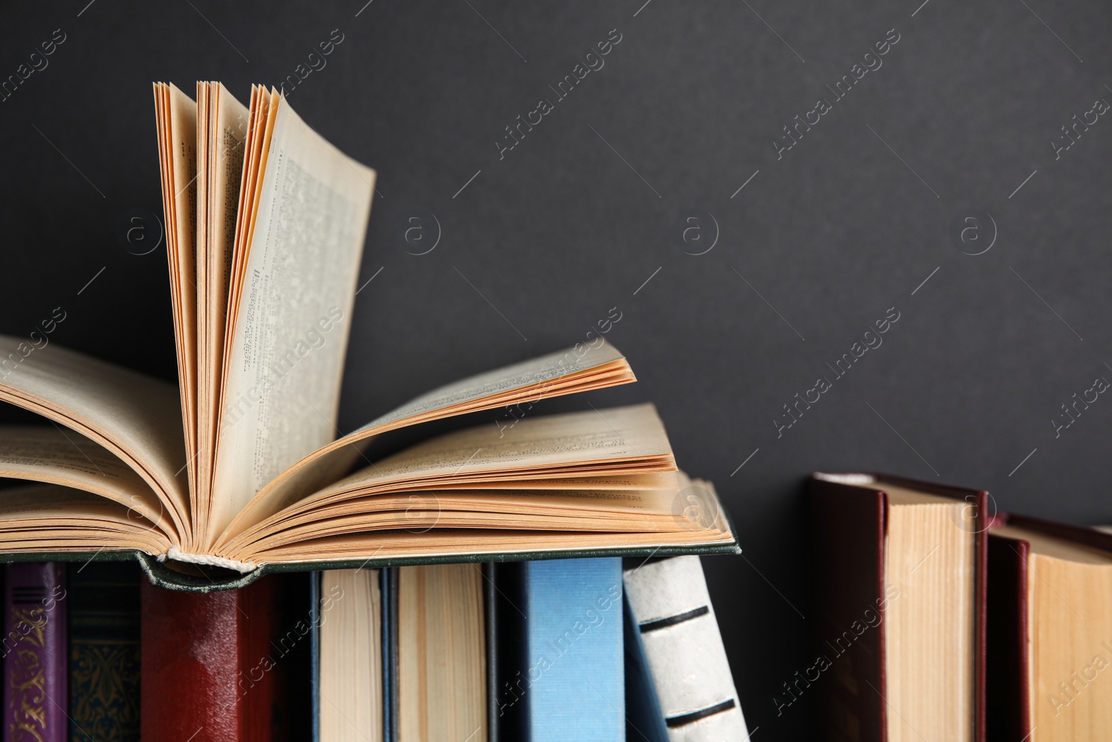 Photo of Different hardcover books against black background, closeup