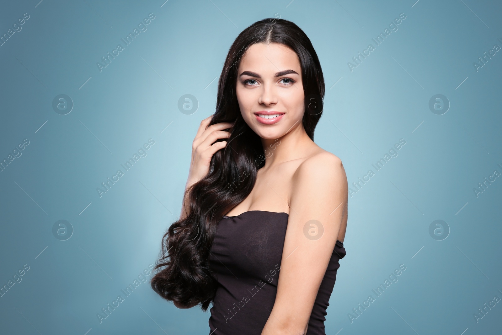 Photo of Portrait of beautiful model with gorgeous curly hair on color background