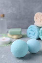 Beautiful aromatic bath bombs on light grey table, closeup. Space for text