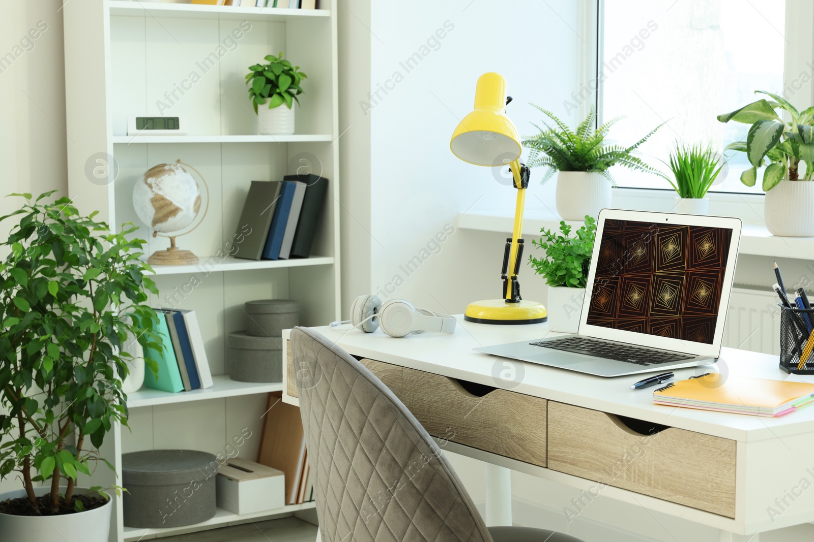 Photo of Cozy workspace with laptop on white wooden desk at home