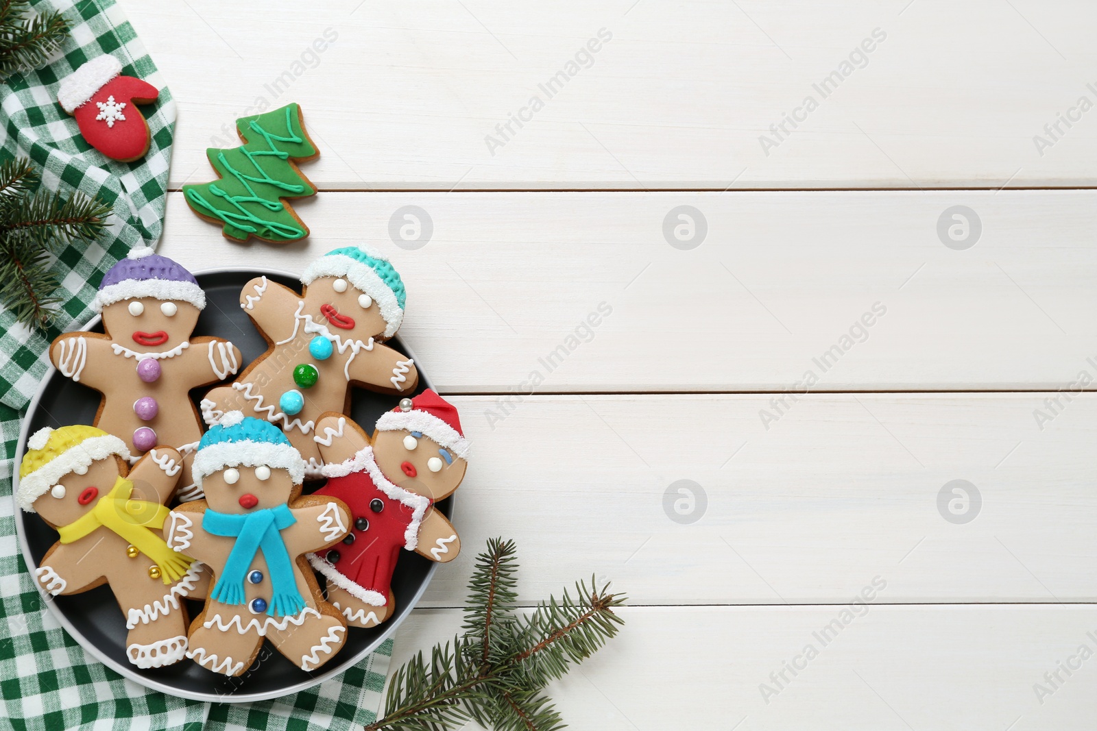 Photo of Delicious Christmas cookies and fir branches on white wooden table, flat lay. Space for text