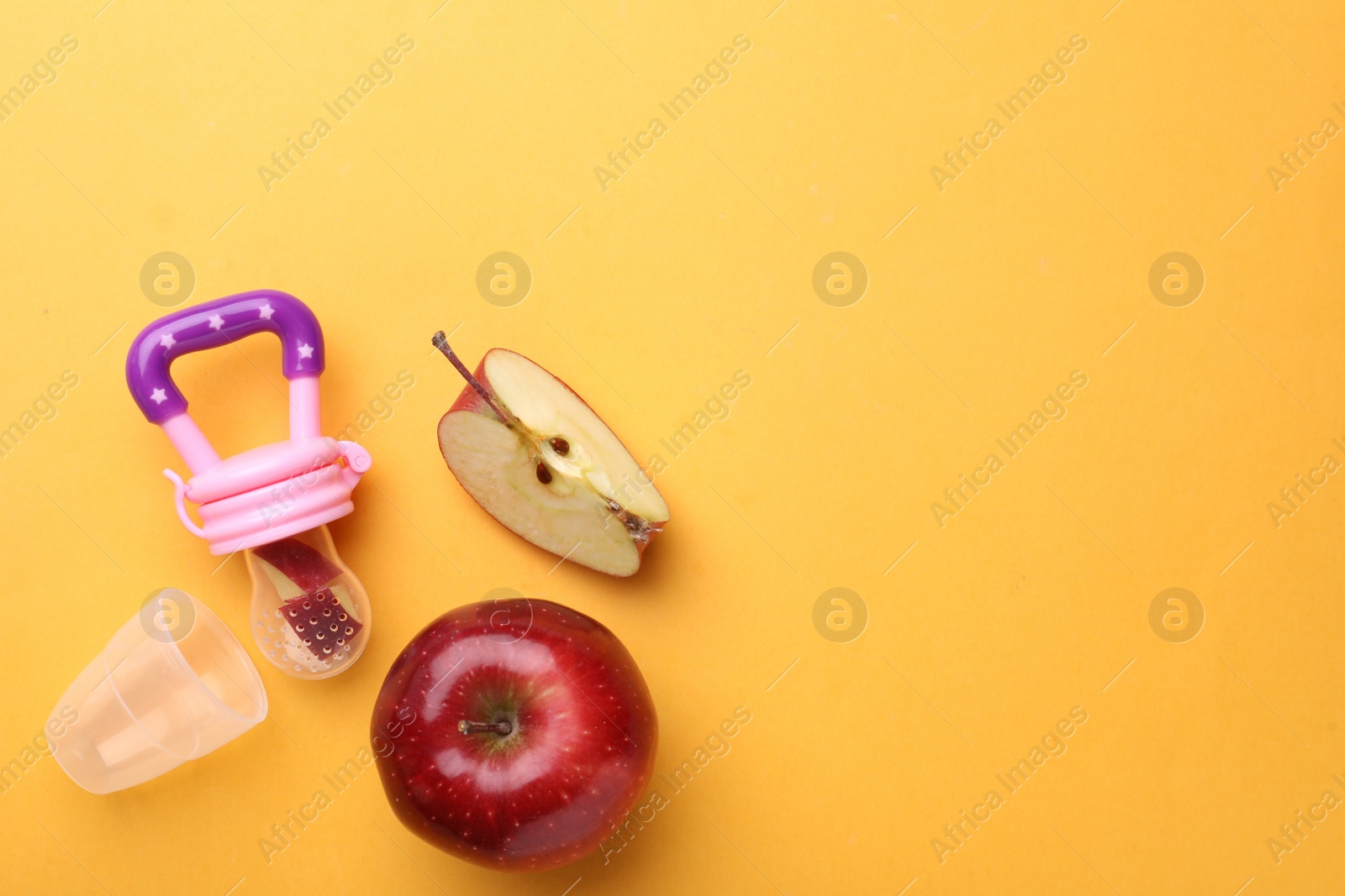 Photo of Nibbler with fresh apple on yellow background, flat lay. Space for text
