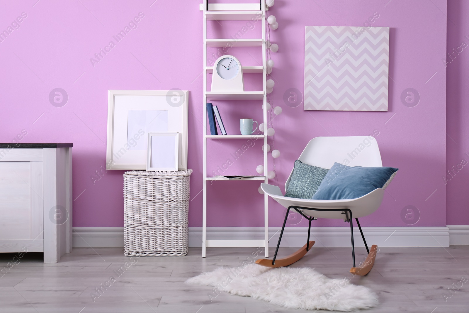 Photo of Stylish room interior with comfortable rocking chair and shelving unit