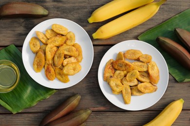 Tasty deep fried banana slices and fresh fruits on wooden table, flat lay