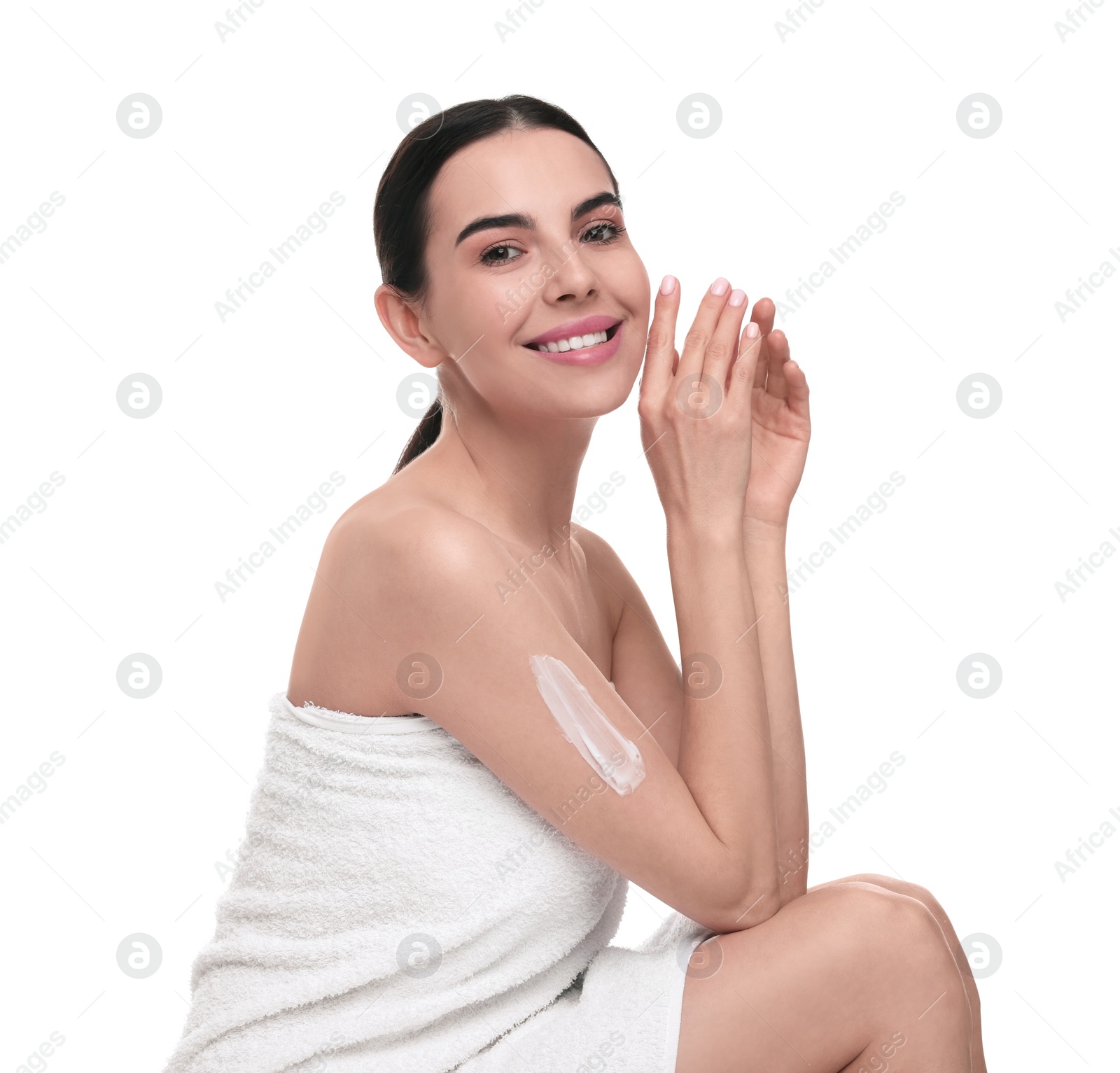 Photo of Beautiful woman with smear of body cream on her arm against white background