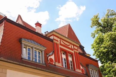 Photo of Beautiful building and green tree against cloudy sky, low angle view