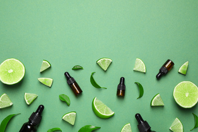 Flat lay composition with lime essential oil on green background. Space for text