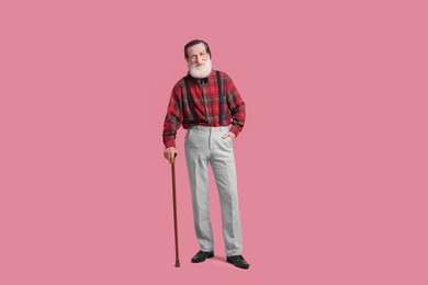Photo of Senior man with walking cane on pink background