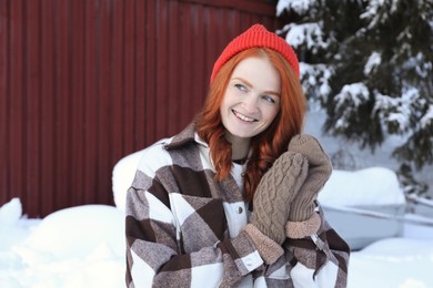 Portrait of beautiful young woman on snowy day outdoors. Winter vacation