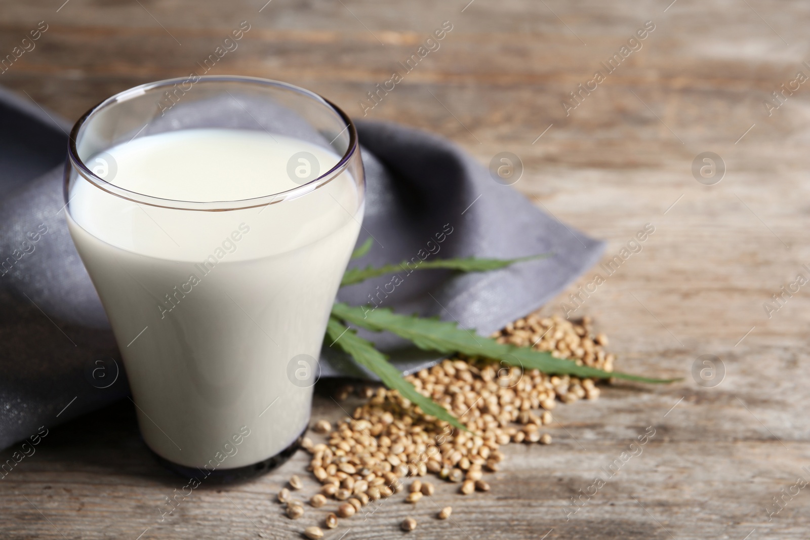 Photo of Glass of hemp milk on wooden table