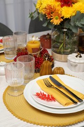 Photo of Autumn table setting with floral decor and pumpkins indoors