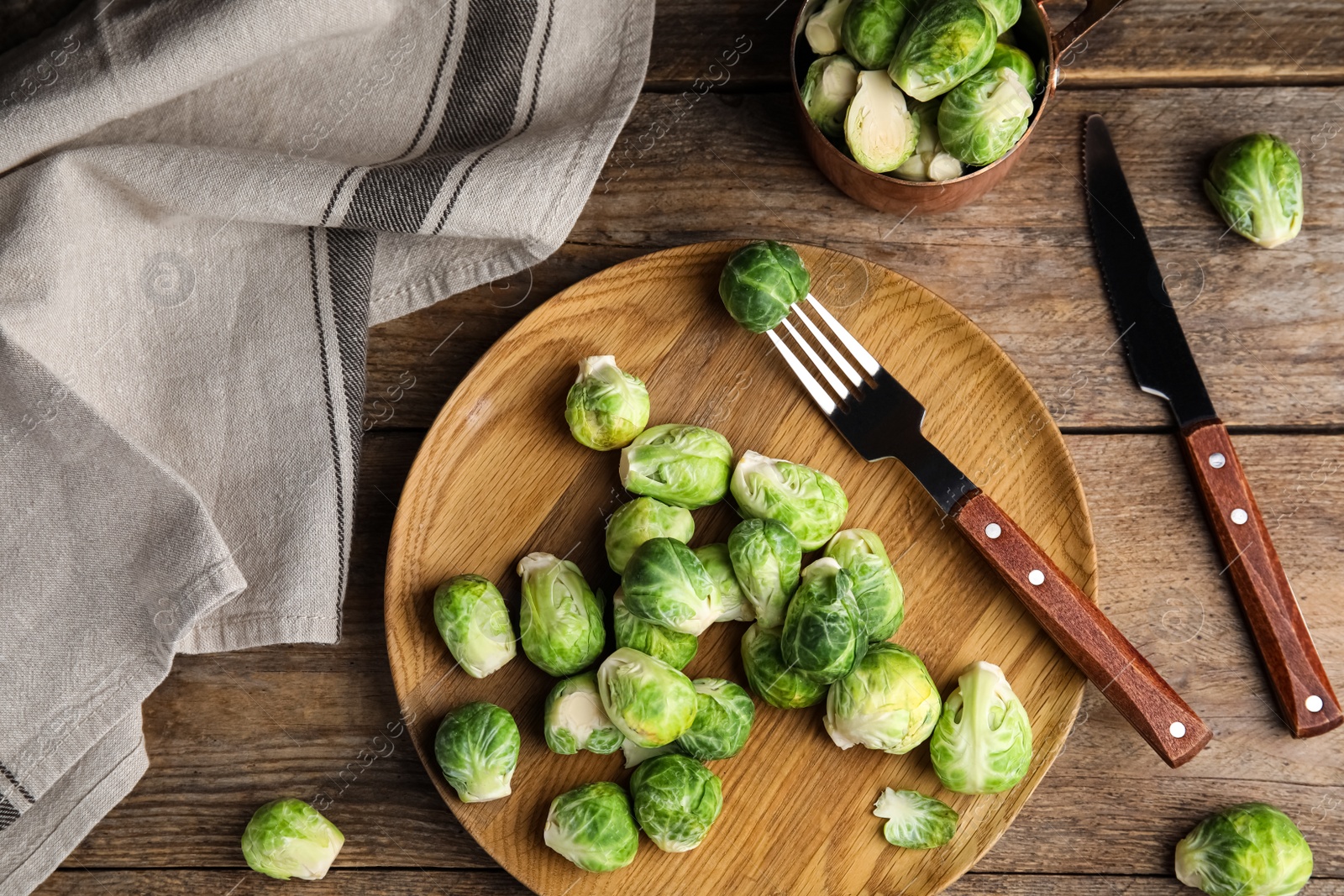Photo of Fresh Brussels sprouts on wooden table, flat lay
