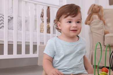 Cute little boy playing with toy in room at home