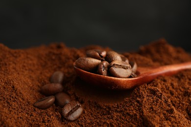 Photo of Coffee grounds and roasted beans on dark background, closeup