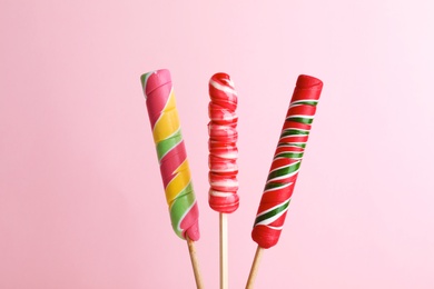 Different bright yummy candies on color background