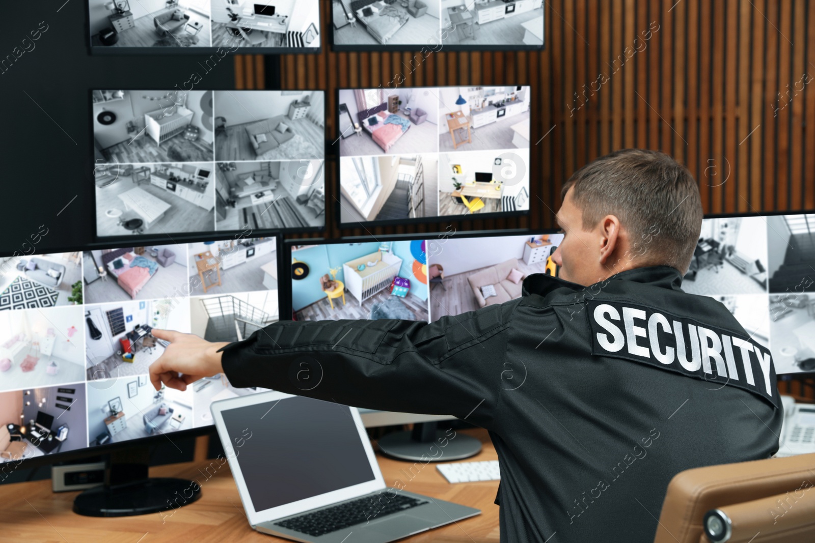 Photo of Security guard with portable transmitter monitoring modern CCTV cameras indoors