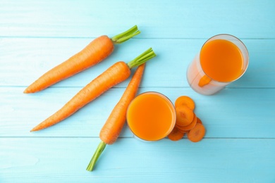 Photo of Glasses with carrot juice and fresh vegetable on wooden table, top view