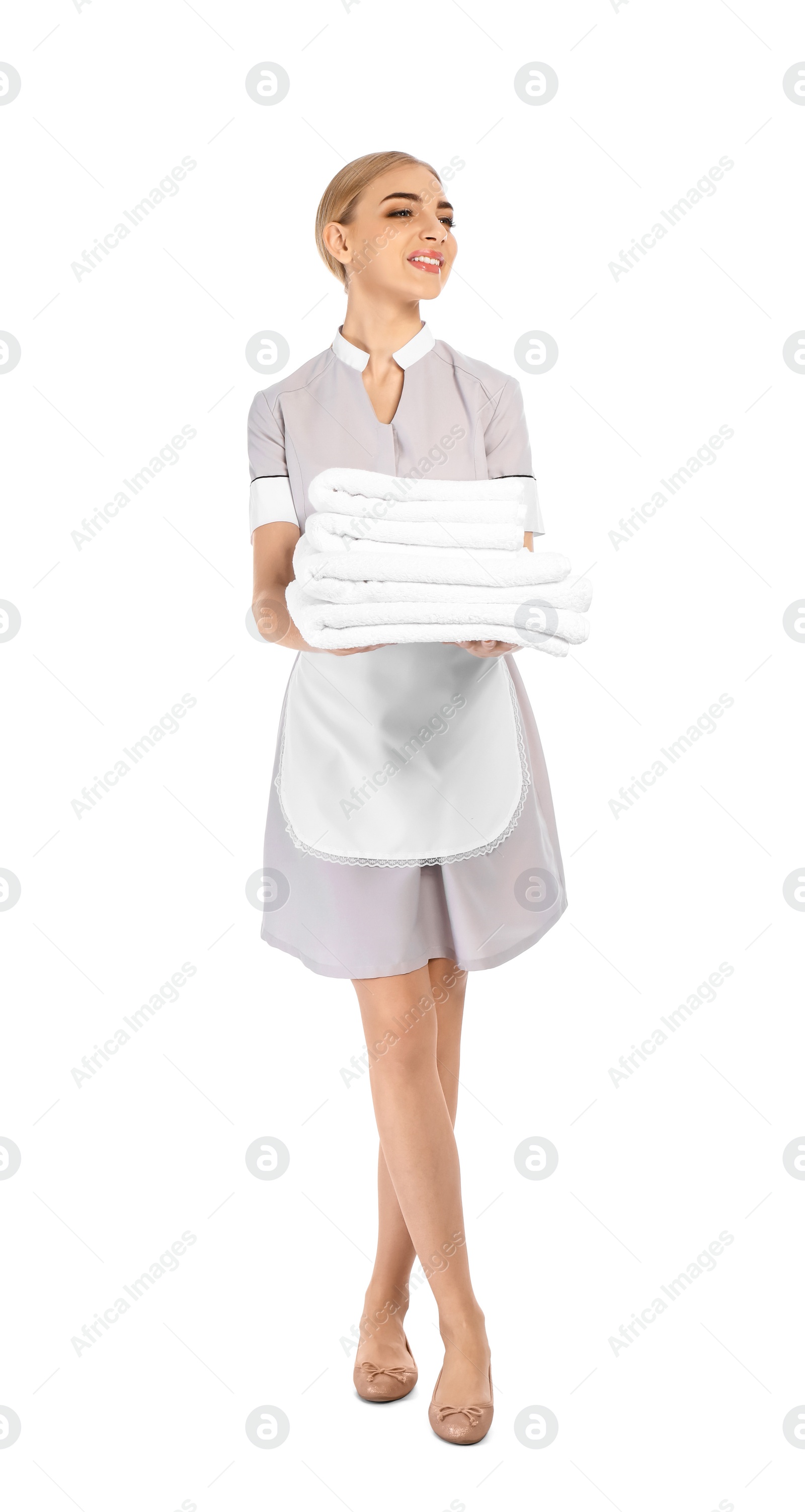 Photo of Young chambermaid with stack of clean towels on white background