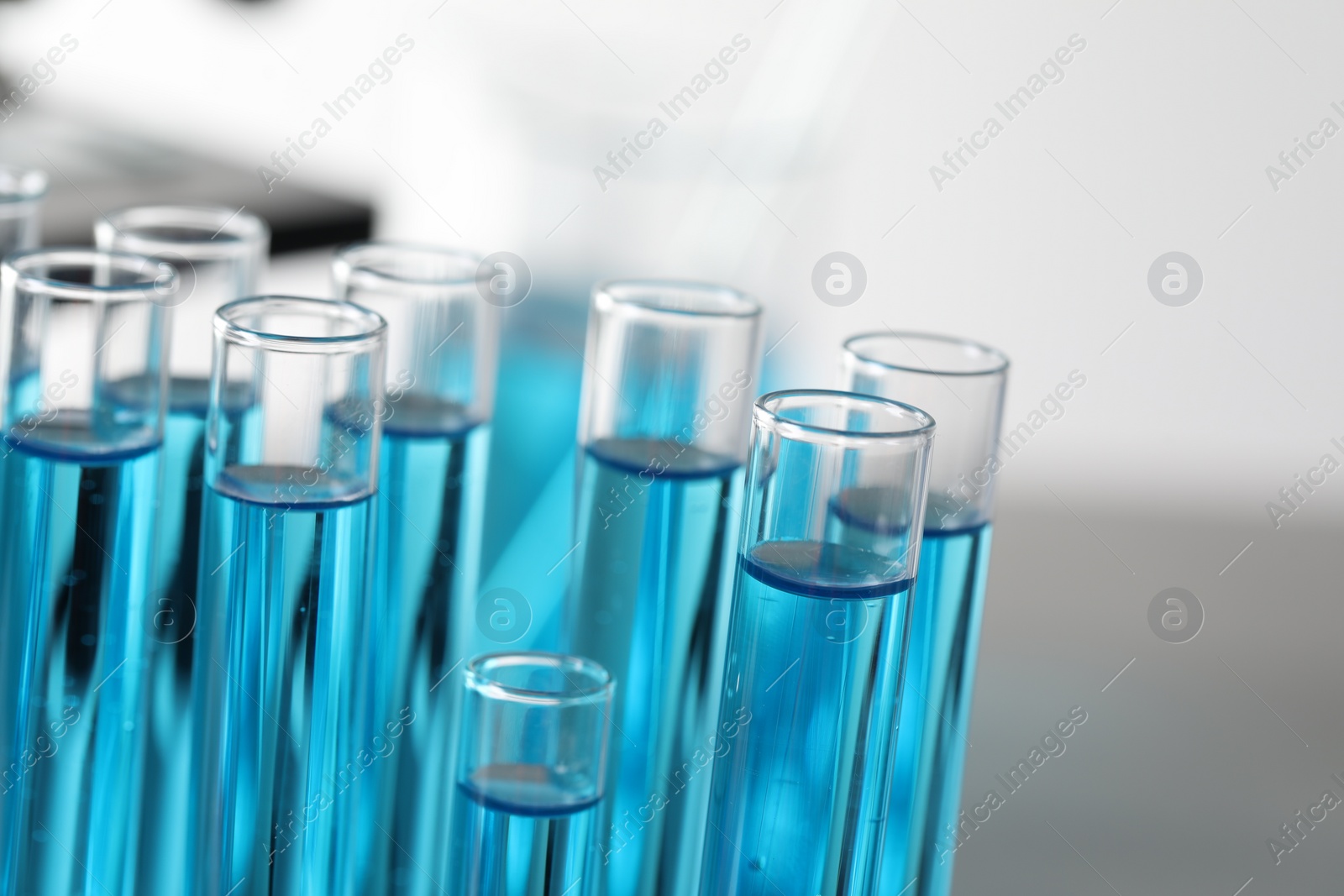 Photo of Test tubes with light blue liquid in laboratory, closeup