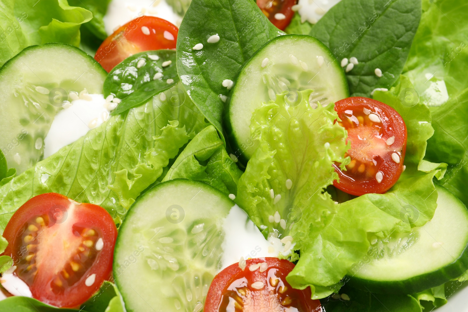 Photo of Delicious salad with cucumbers and tomatoes as background, closeup