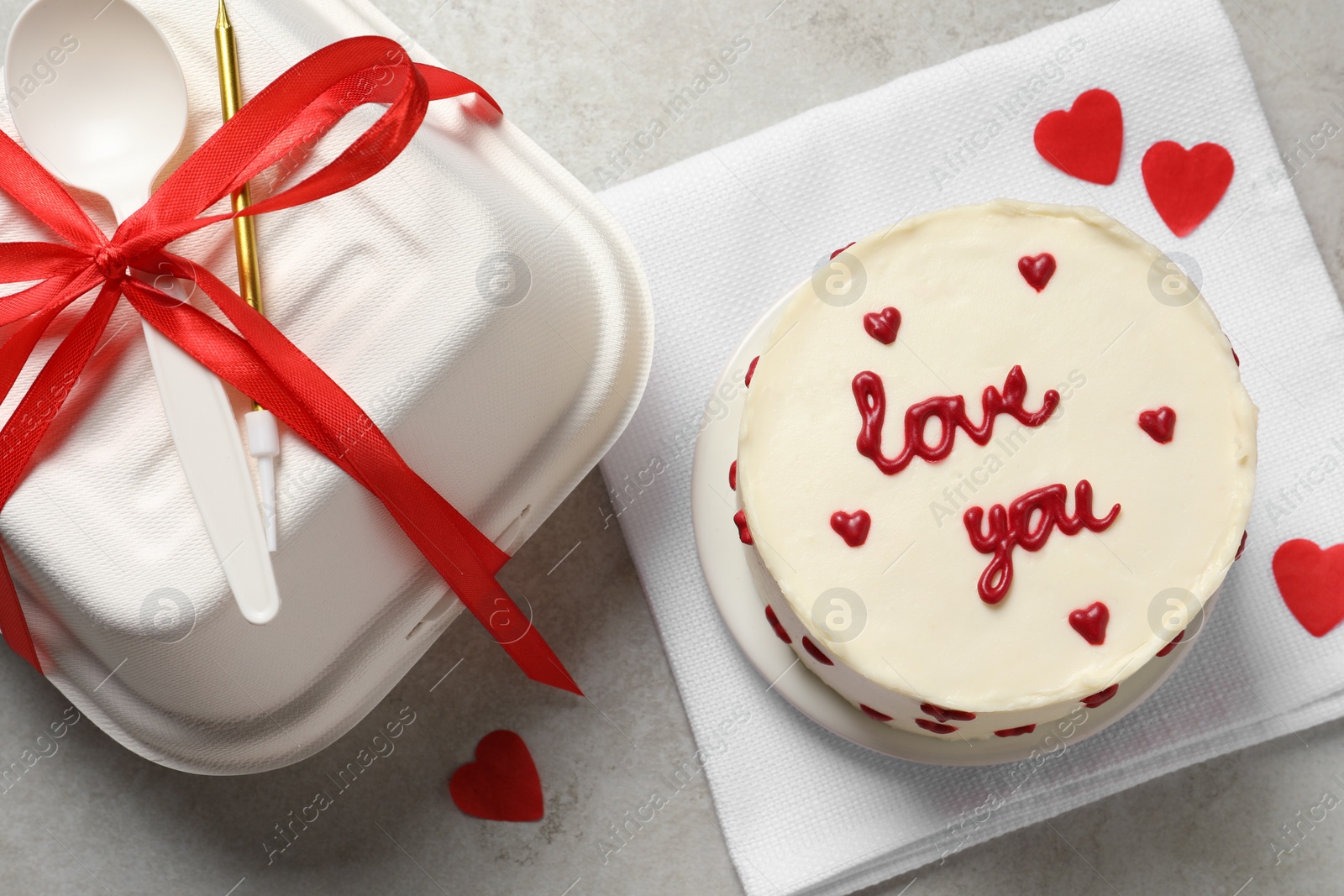 Photo of Bento cake with text Love You, takeaway packaging and gift box on grey table, flat lay. St. Valentine's day surprise