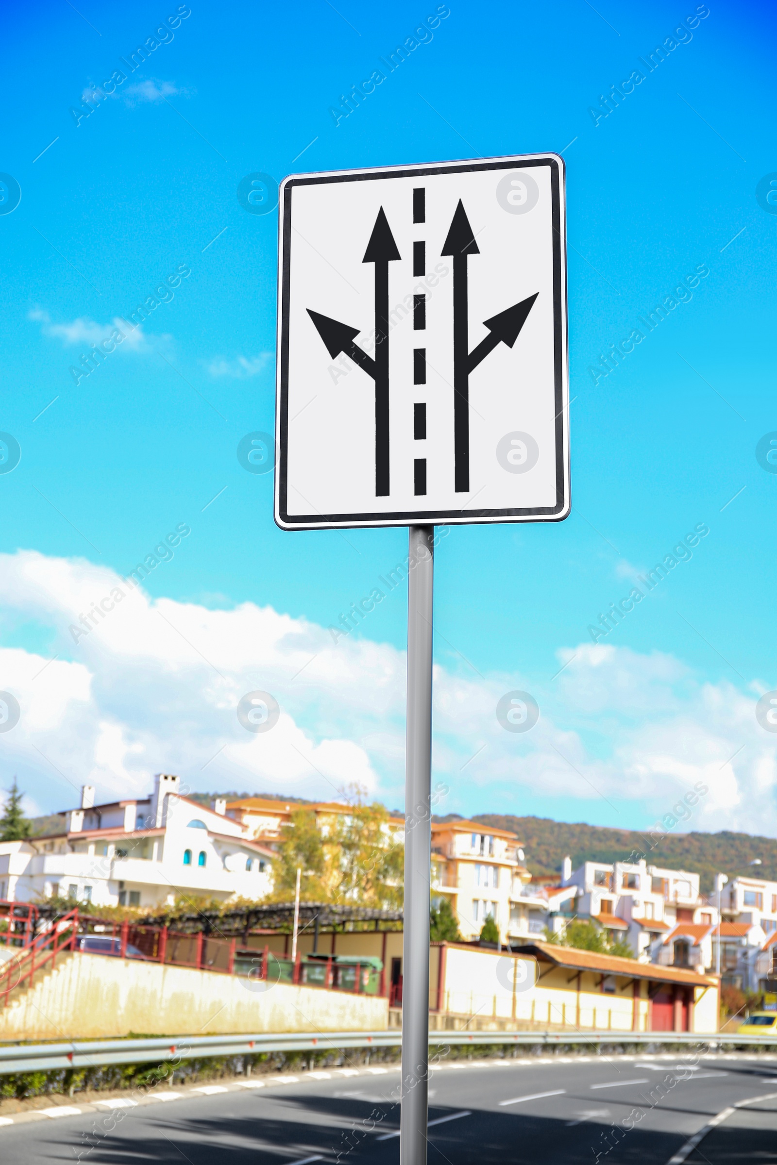 Photo of Post with road sign against cloudy sky in city
