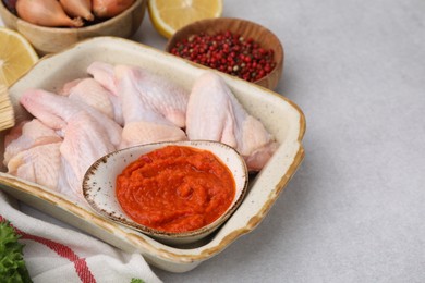 Fresh marinade, raw chicken and other products on light textured table, closeup. Space for text