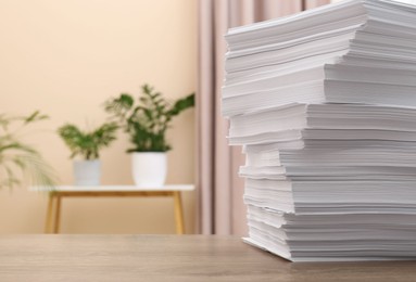 Stack of paper sheets on wooden table indoors. Space for text