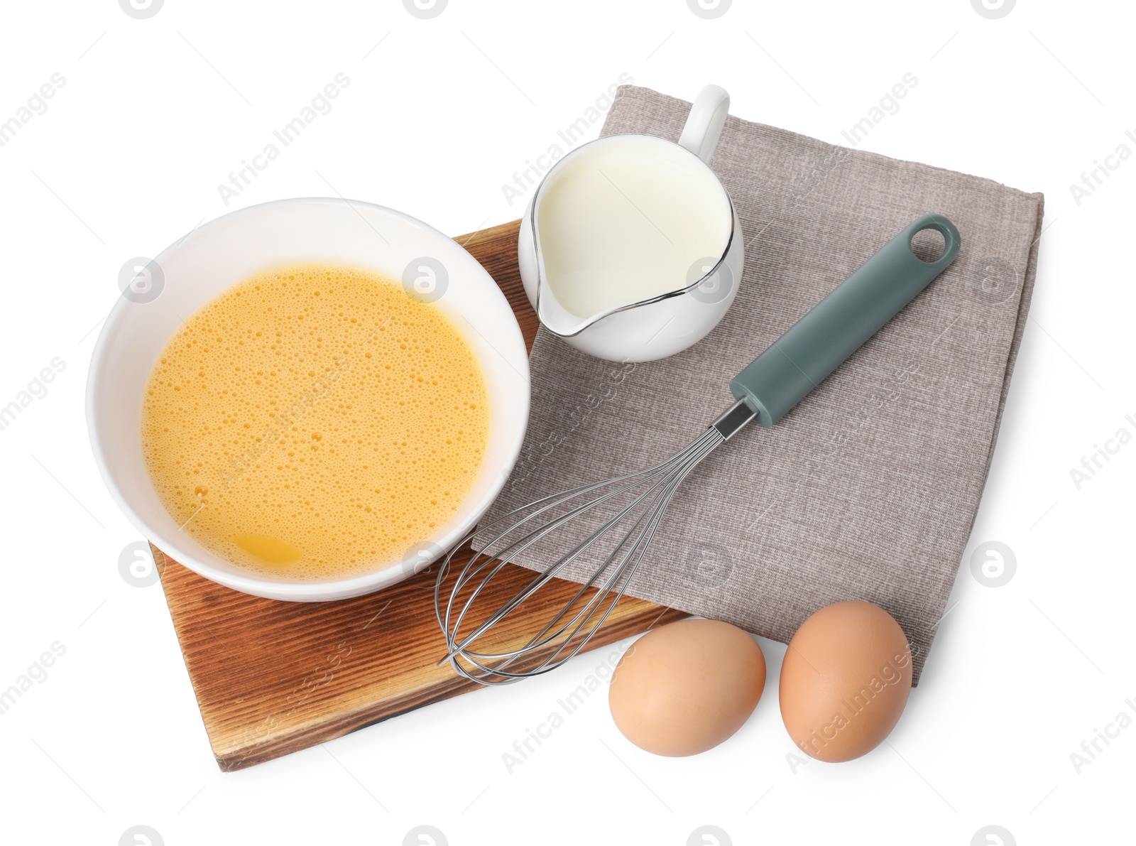 Photo of Metal whisk, beaten eggs and milk isolated on white
