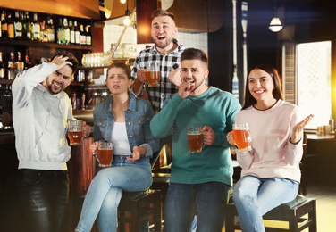 Group of friends watching football in sport bar