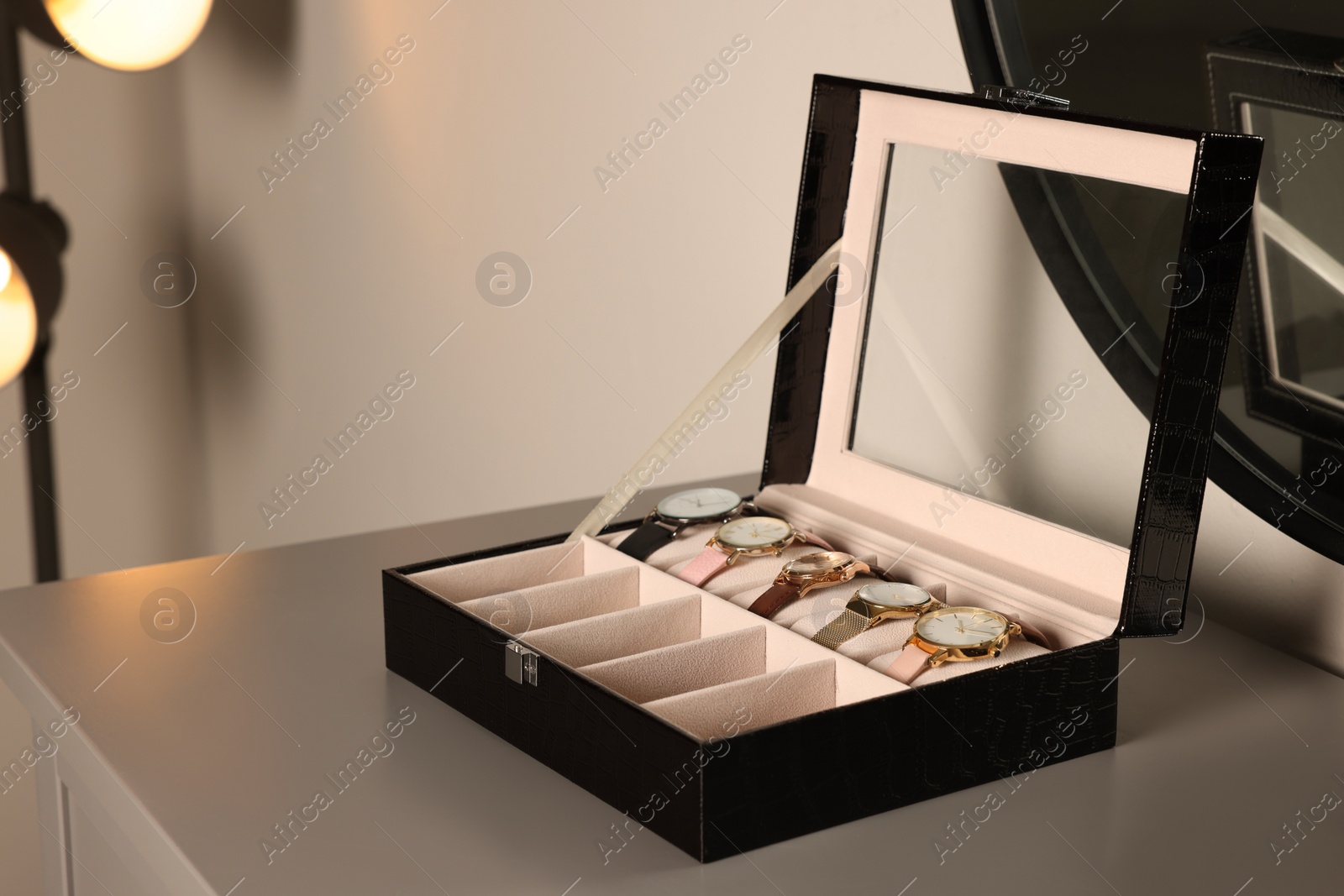 Photo of Elegant jewelry box with expensive wristwatches on grey table indoors